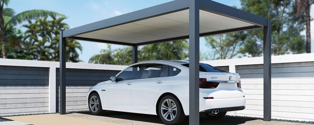 Carport Prestige aluminum roof structure with a slatted side enclosure, showing how the system can create a more sheltered and visually coordinated outdoor space.
